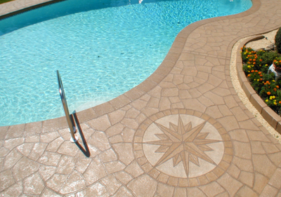 concrete pool patio stamped with sand color compass. 