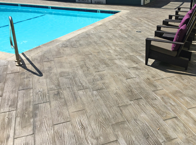 concrete pool deck stamped with a wood grain pattern.