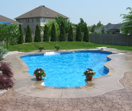 Concrete patio with in-ground pool with stamped concrete.